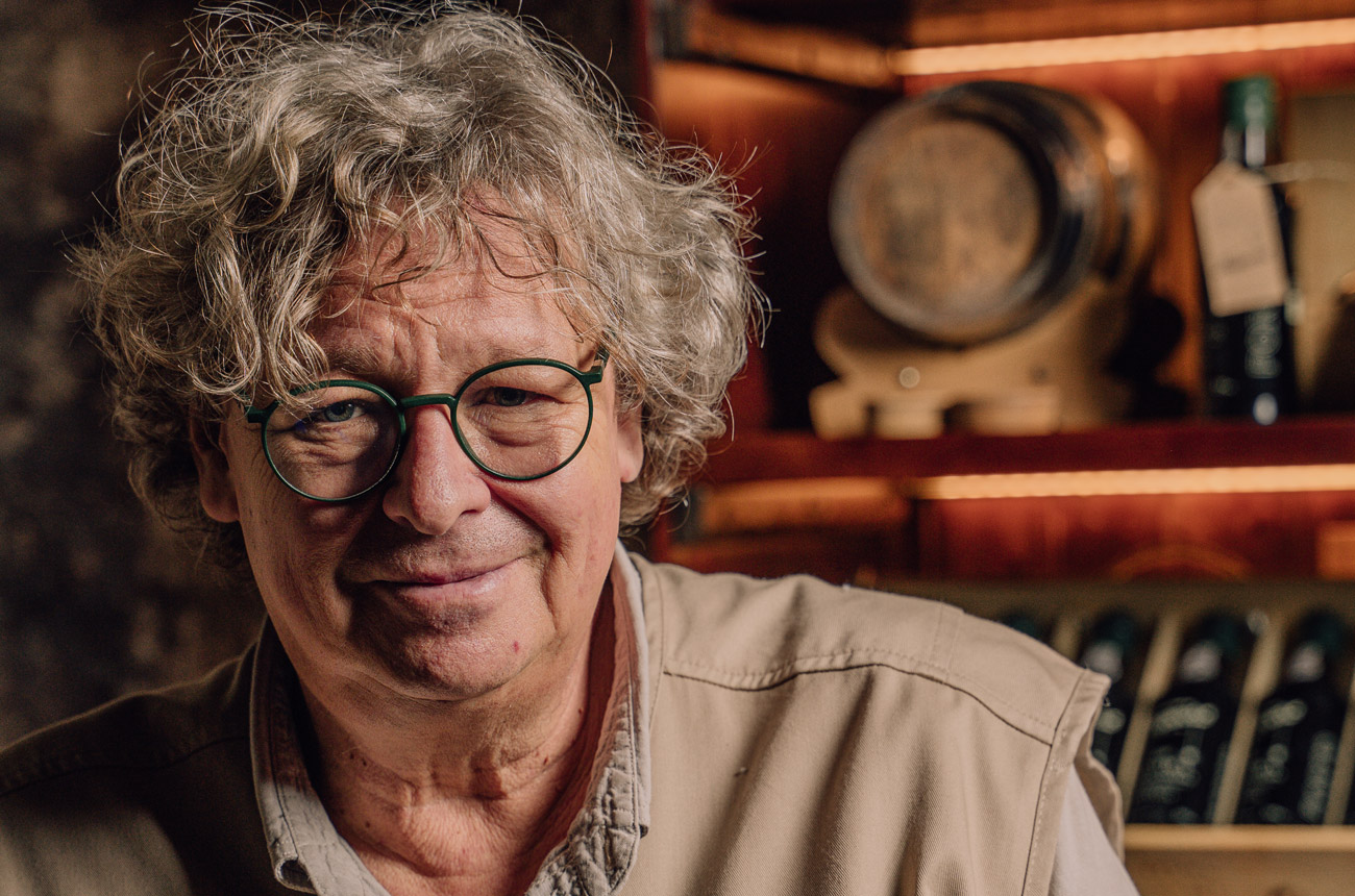A grey haired man wearing glasses