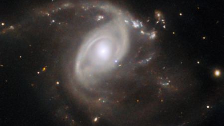 This Hubble Space Telescope image features the galaxy LEDA 22057, which is located about 650 million light-years away in the constellation Gemini. LEDA 22057 is the site of a supernova explosion, named SN 2024PI, which is visible in this image: located just down and to the right of the galactic nucleus. 