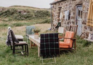 rustic outdoor living area with cosy picnic blankets on the chairs