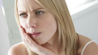 What causes toothache? image shows woman with toothache
