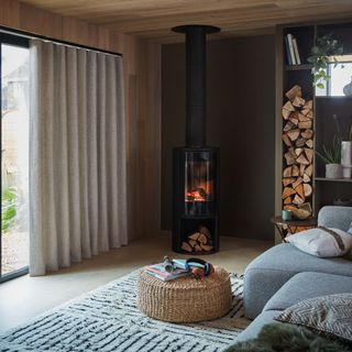 Neutral curtains in a modern living room with a contemporary wood burner