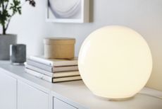 A table with books and a spherical lamp
