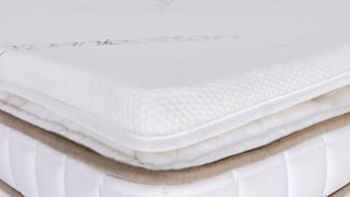 Best mattress toppers: Image shows the Saatva mattress topper on a white bed frame