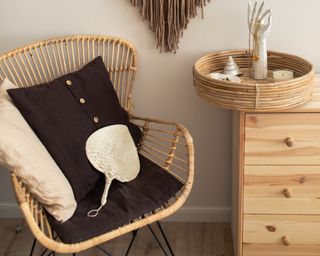boho arm chair with wooden dresser and wall hanging