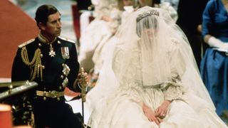 The wedding of Princess Diana and Prince Charles in 1981, Diana is in her voluminous wedding dress with her veil over her face and Charles next to her in his military attire whilst they say their vows