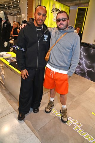 LONDON, ENGLAND - JULY 02: Lewis Hamilton (L) and Kim Jones celebrate the launch of his +44 'Home Turf' collection, available exclusively at Selfridges London and online at www.pluss44.world, on July 2, 2024 in London, England. (Photo by Dave Benett/Getty Images for Selfridges)