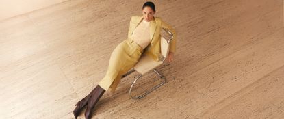 Model wearing a Yellow two piece set and brown boots sat on a yellow chair from a birds eye view