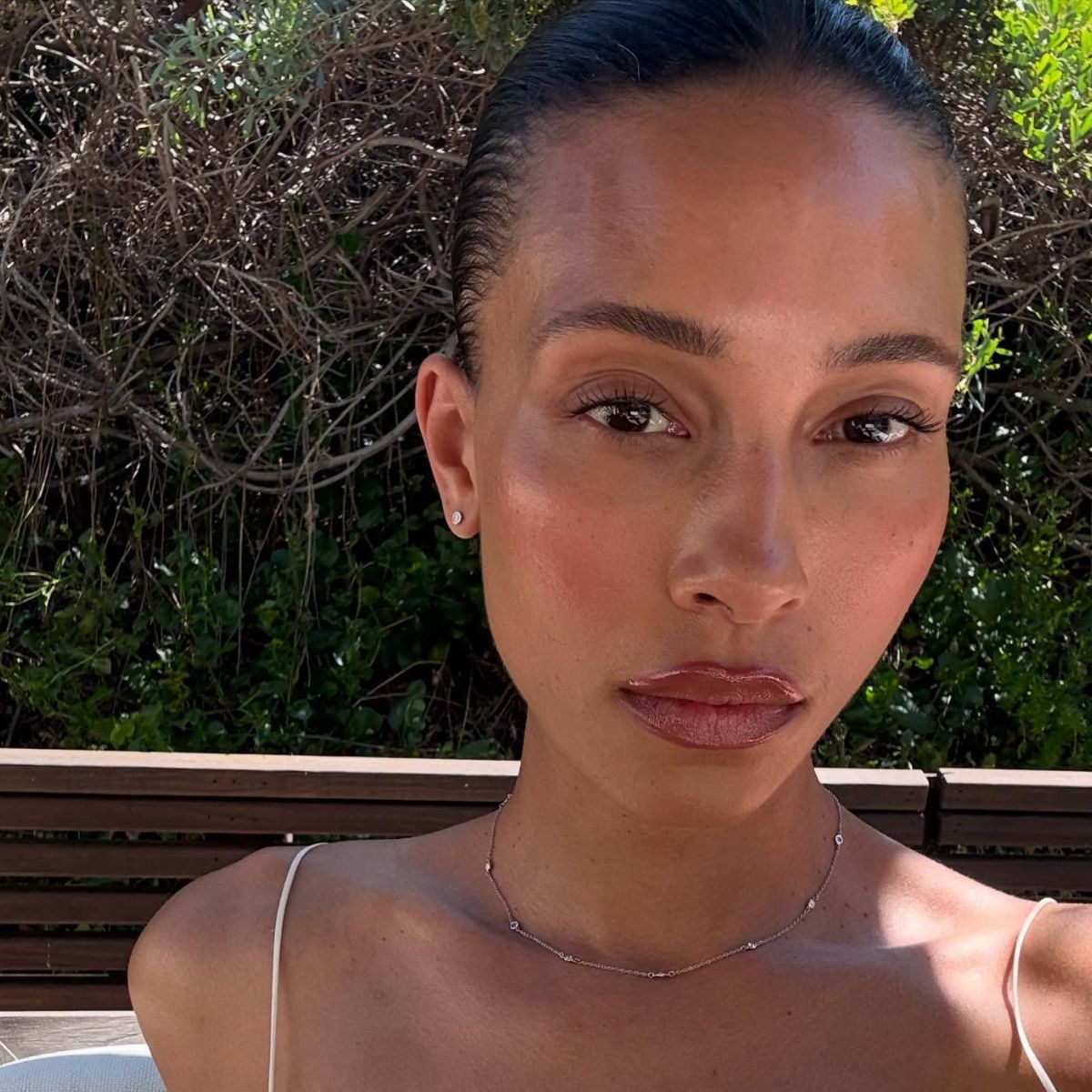 @tylynnnguyen taking a selfie in the sunshine with glowing skin
