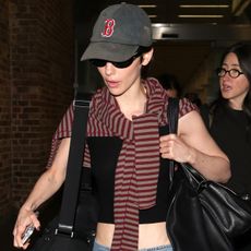 gracie wears a boston hat, stripe sweater, and a black tank with low-rise jeans.