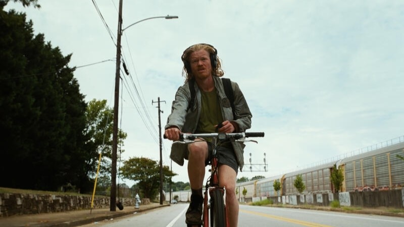 Jesse Plemons riding a bike in Bugonia