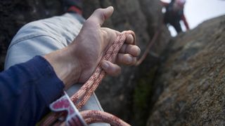 Close up of a climber's hands belaying partner
