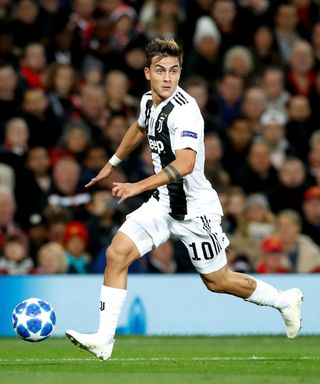 Paulo Dybala runs with the football in front of his right boot