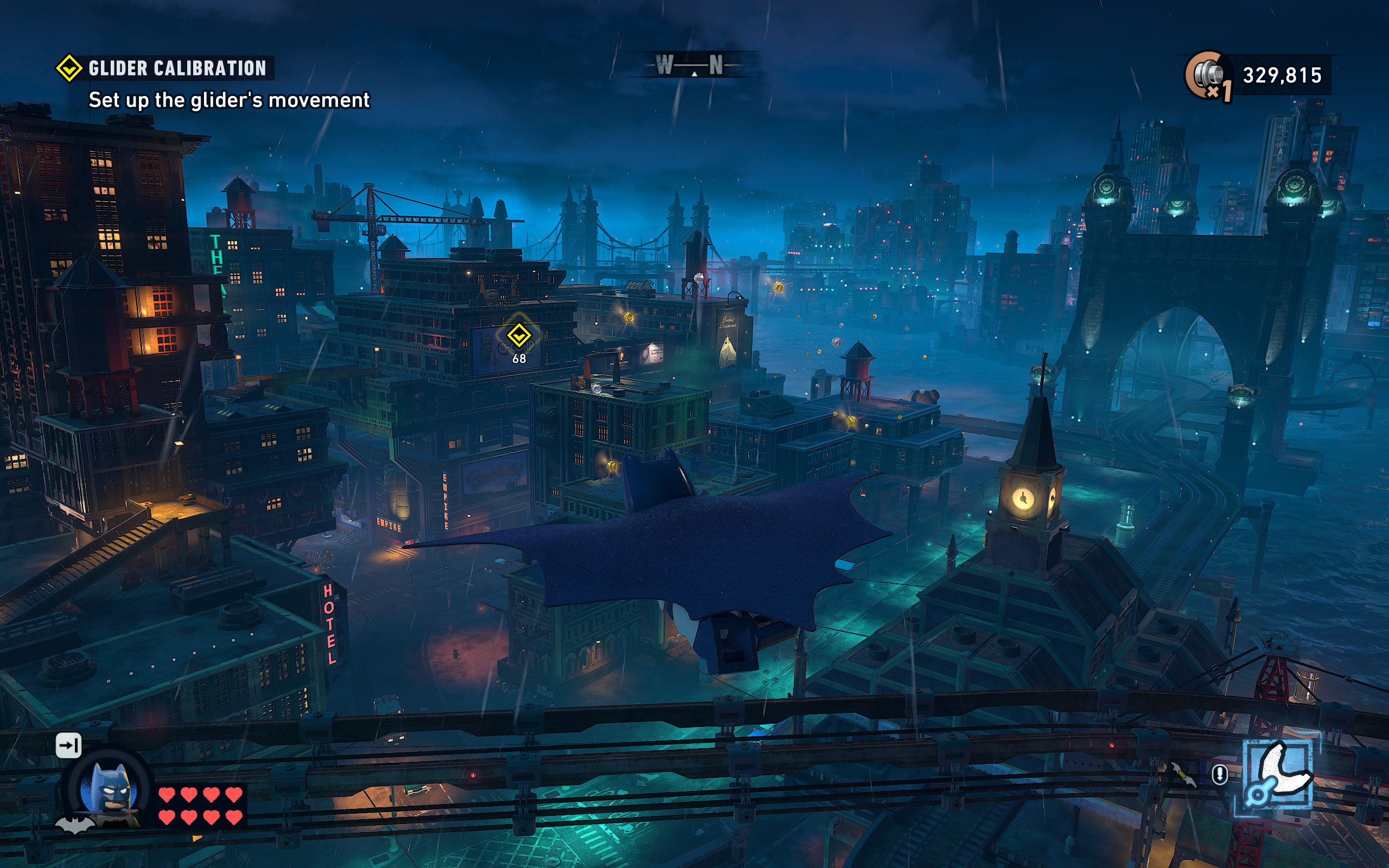 Batman glides over the streets of Gotham City in the rain