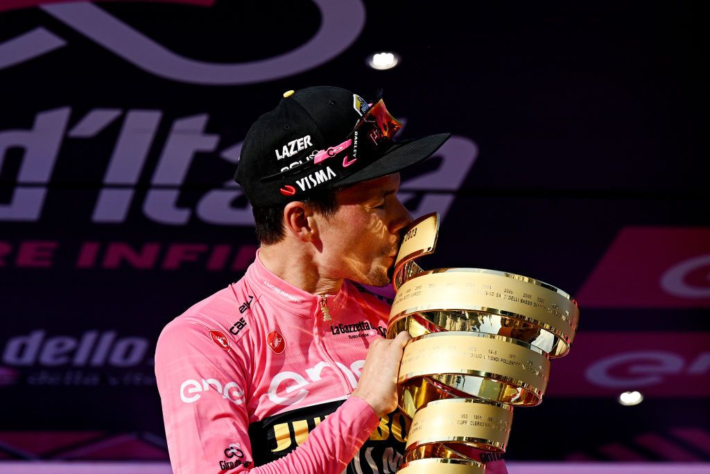 Primo Roglic celebrates with the winner trophy, Trofeo Senza Fine, after securing the overall title at the 2023 Giro d&#039;Italia