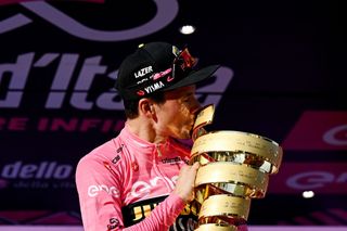 Primo Roglic celebrates with the winner trophy, Trofeo Senza Fine, after securing the overall title at the 2023 Giro d'Italia