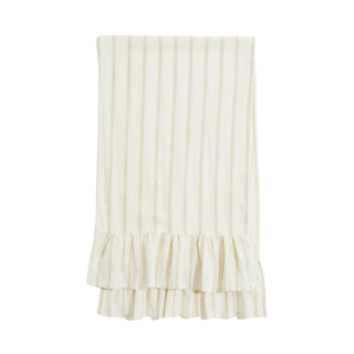 A beige striped ruffle-trimmed table runner