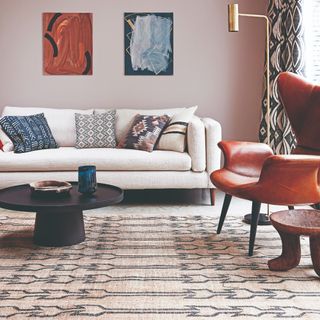 A pink-painted living room with a cream sofa and a patterned rug