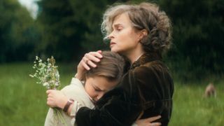 L-R: Lady Eileen Brent (Mia McKenna-Bruce) and Lady Caterham (Helena Bonham Carter) hug in a scene from Netflix's "Agatha Christie's Seven Dials"