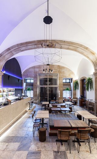 One of the bar restaurants in the Palacio Chiado that has a more modern look. Tall ceilings, with the bar to the left. Ligh and dark brown tables are set throughout the area, with dark wooden chairs.