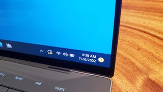 A Dell XPS 13 Plus on a table with a close up of the Windows 11 taskbar