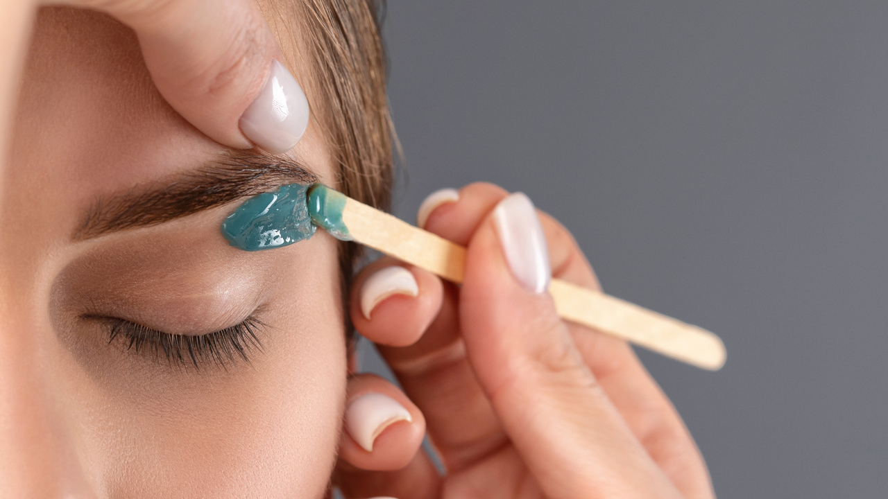 Close up image of a woman having her eyebrows waxed - Eyebrow waxing