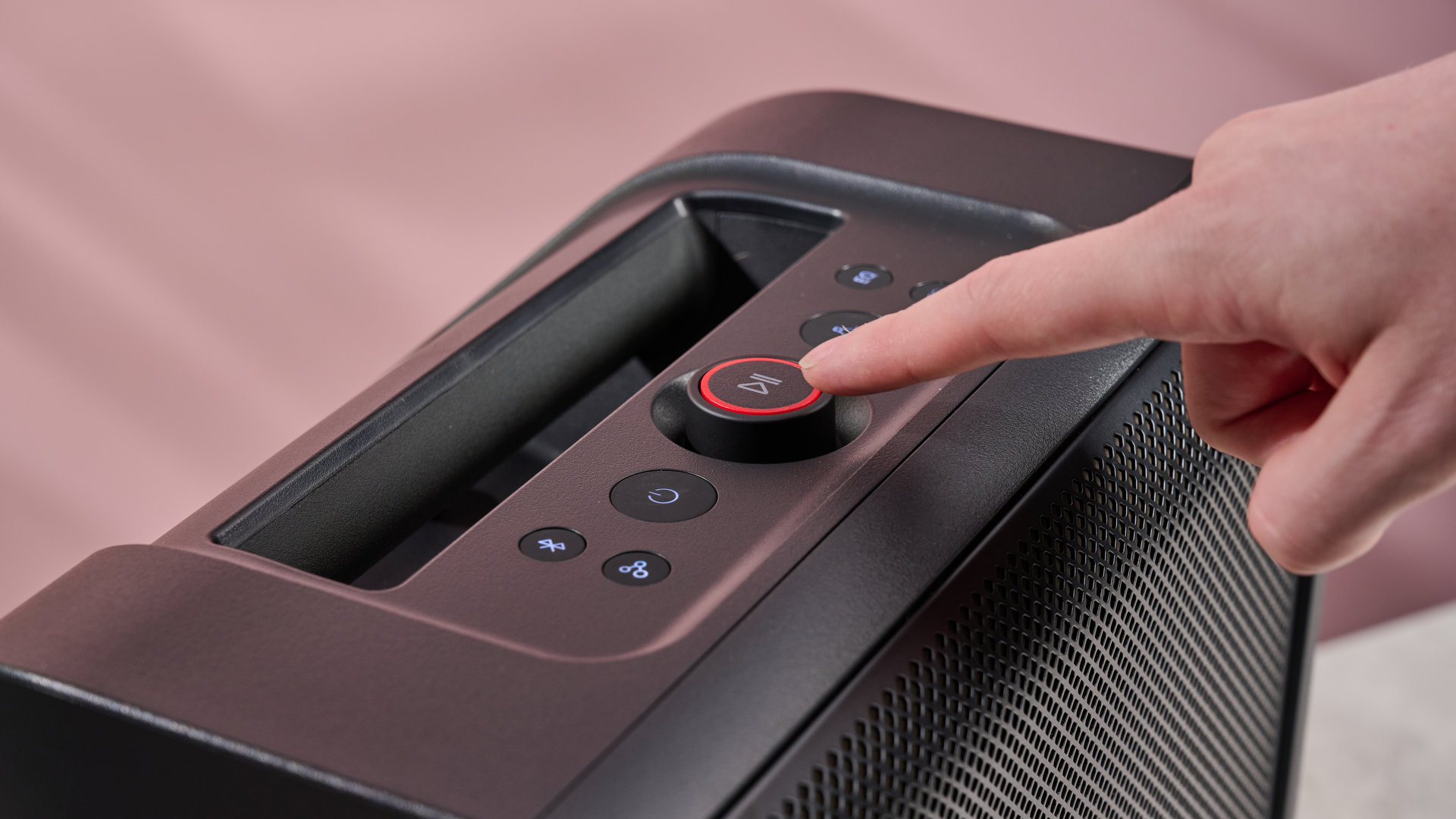 Person pressing the play button on the LG xboom Stage 301