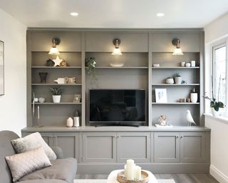 Grey built in cabinets with accent living room lighting.