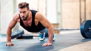 Man performing push-ups in gym studio during workout