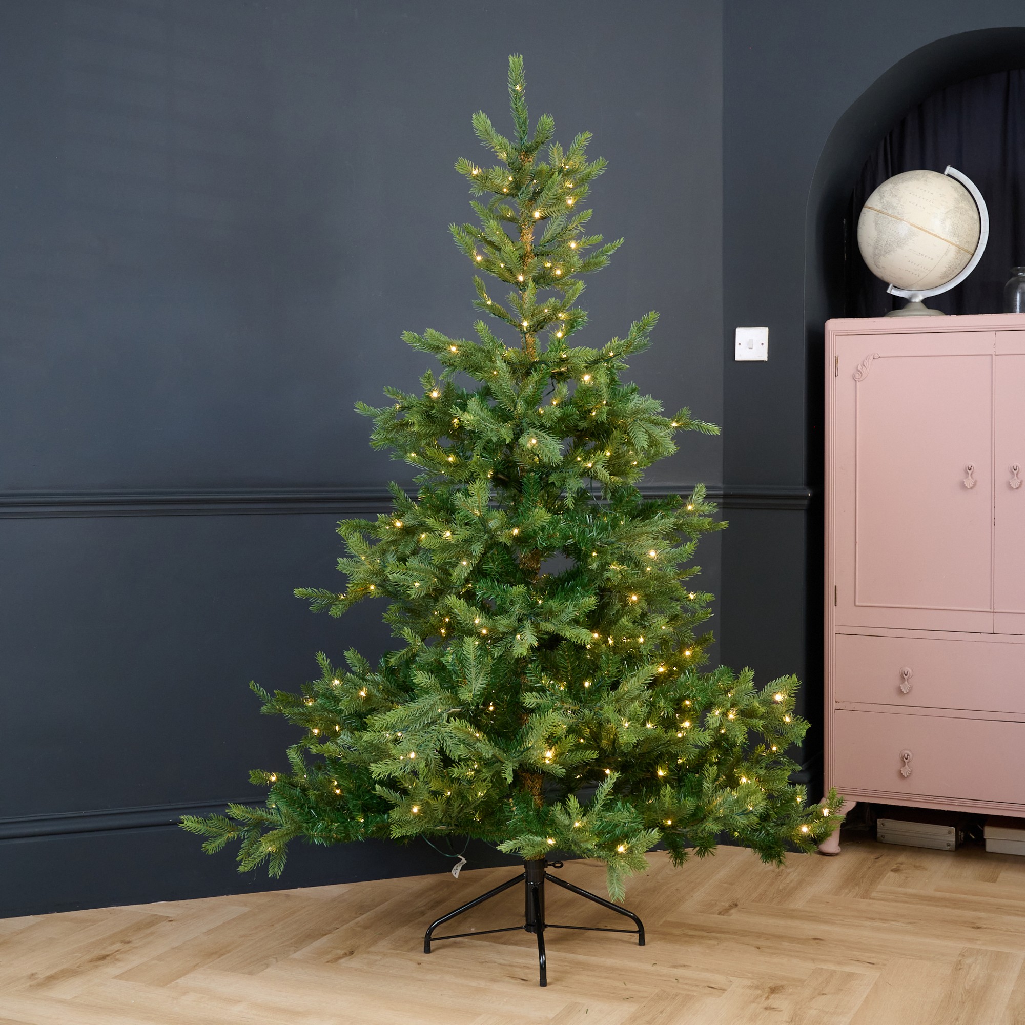 Cox & Cox's 6ft Bergen Spruce Pre-Lit Christmas Tree in a black-painted living room