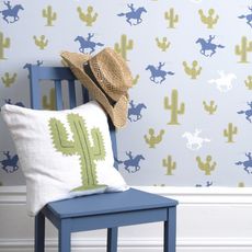 room with wallpaper on wall and pillow and cap on wooden blue chair