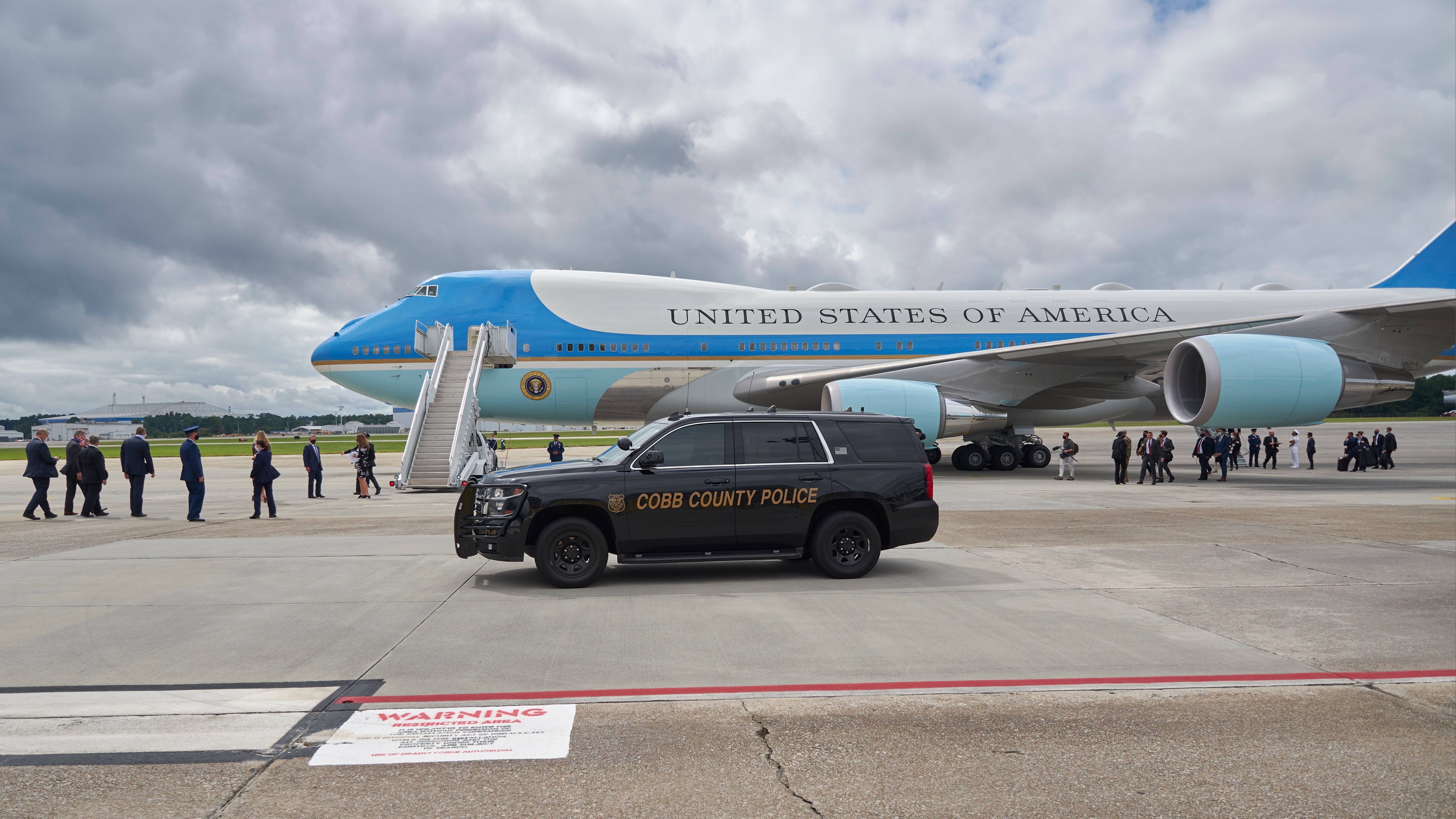 MARIETTA, GA- SEPTEMBER 25, 2020: President Donald Trump arrives on Air Force One at Dobbins Air Reserve Base with a Cobb County Police vehicle assembling in position for the motorcade.
