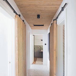 Hallway with wooden farmhouse inspired sliding doors