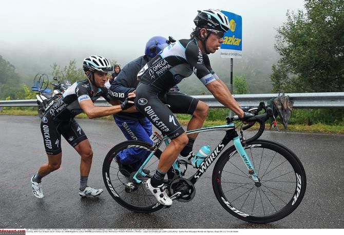 Rigoberto Uran (Omega Pharma-QuickStep) has a mechanical and gets help from his teammate
