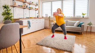 Woman doing sumo squat in living room as an exercise snack