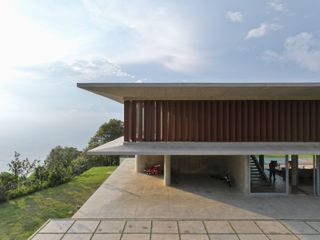 casa cuore in medellin sits in greenery enjoying long nature views that contrast its striking concrete and wood contemporary forms