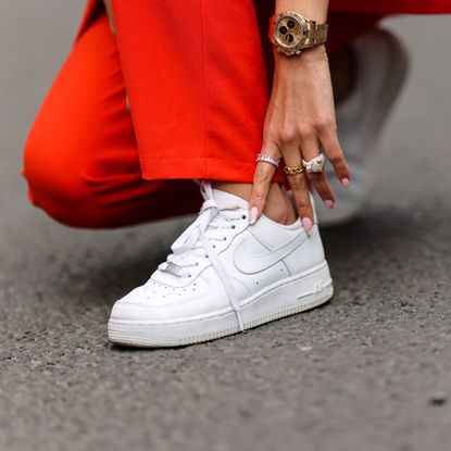 Patricia Gloria Contreras wears a Rolex watch, Nike white sneakers, on April 08, 2021 in Paris, France