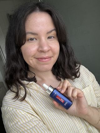 Una imagen de Mica sosteniendo una botella de L'Oréal Paris Pure Retinol Revitalift Laser Night Serum