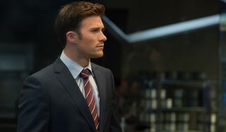Scott Eastwood standing attentively in a suit in The Fate of the Furious.