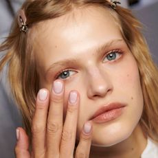 blonde model with glowing skin applying skincare