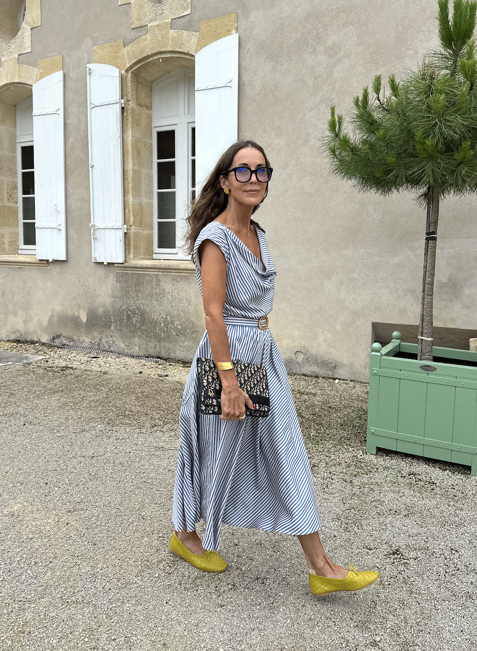 Larissa Mills in a blue and white striped dress and yellow flats