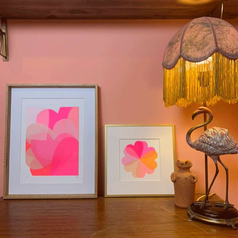Shelf with flamingo lamp base and two pink artworks