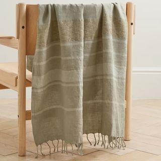 neutral striped linen throw draped over a wooden chair