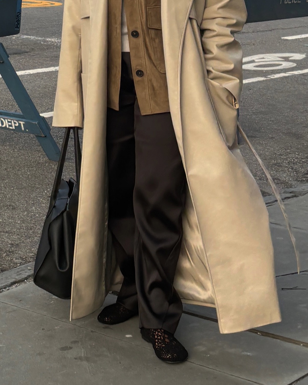Cortne Bonilla wearing black crochet flats with trousers and a trench coat.