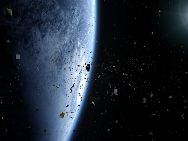 Orbital debris of varying sizes floats in space above Earth