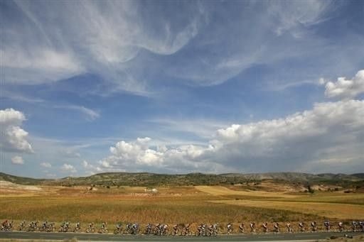 The peloton ride past sweeping plains and blue skies.