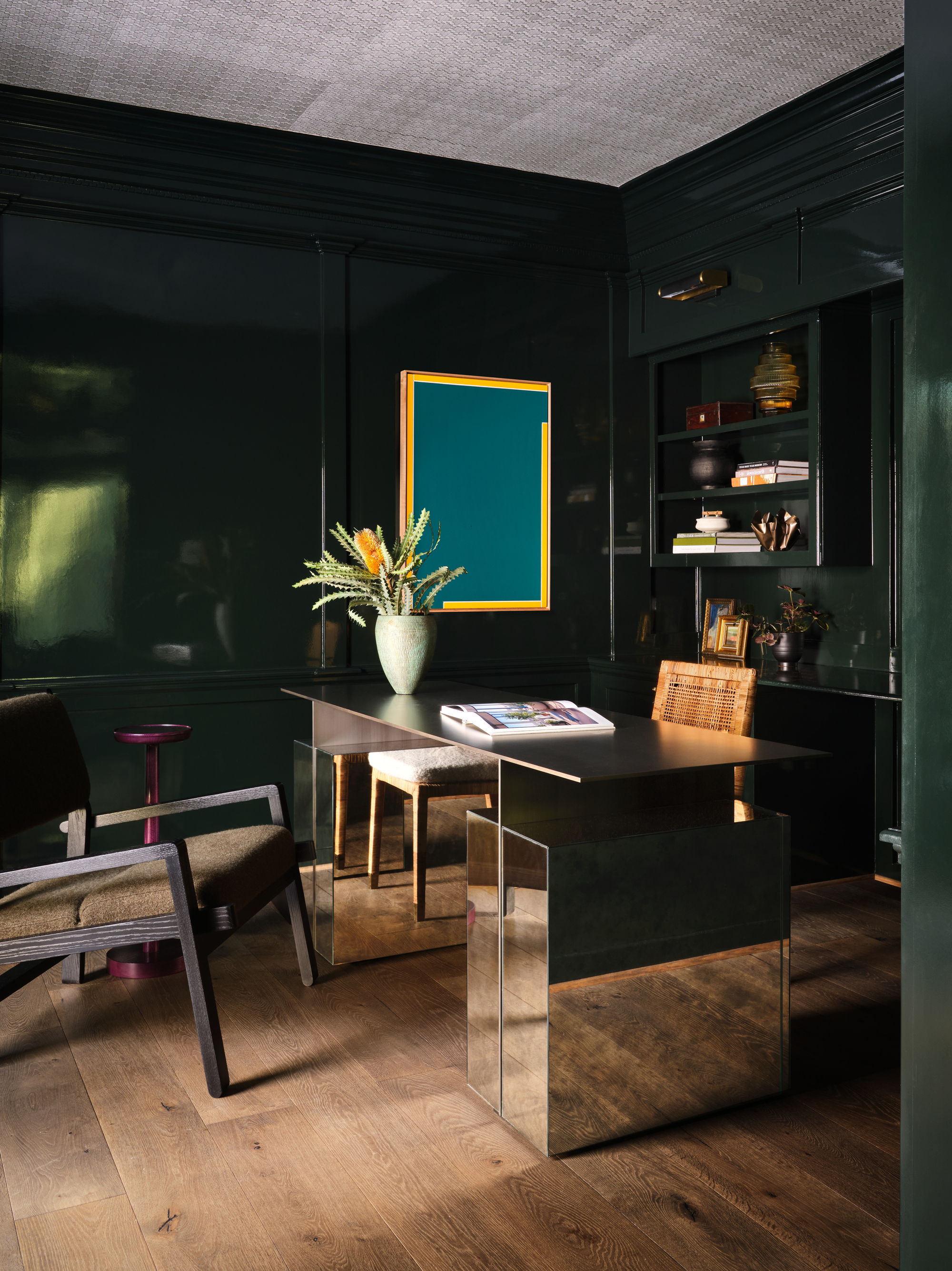 office space with dark green walls, a desk, and chair