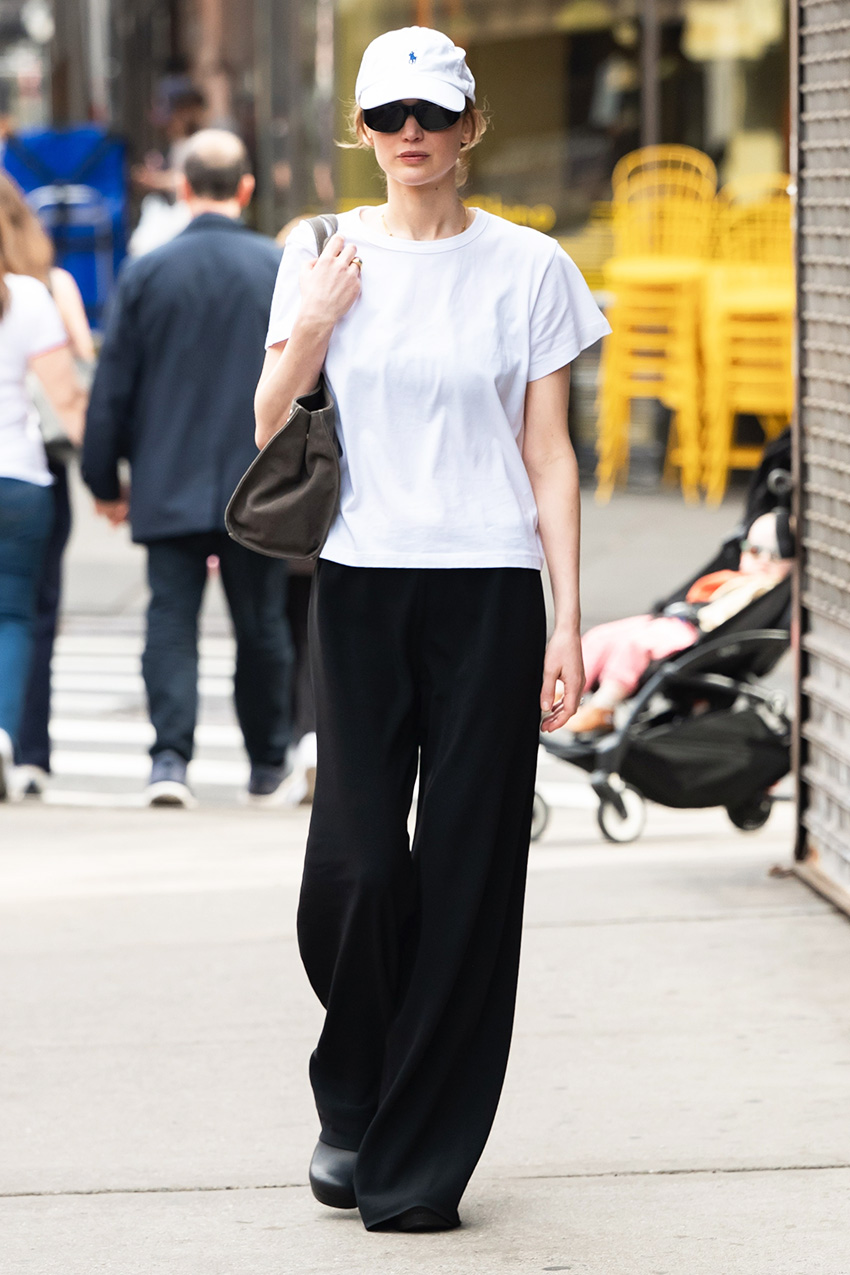 Jennifer Lawrence wearing a white T-shirt, black pull-on pants, black flats, and a Polo Ralph Lauren baseball cap