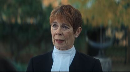 Celia Imrie stands outside in legal robes