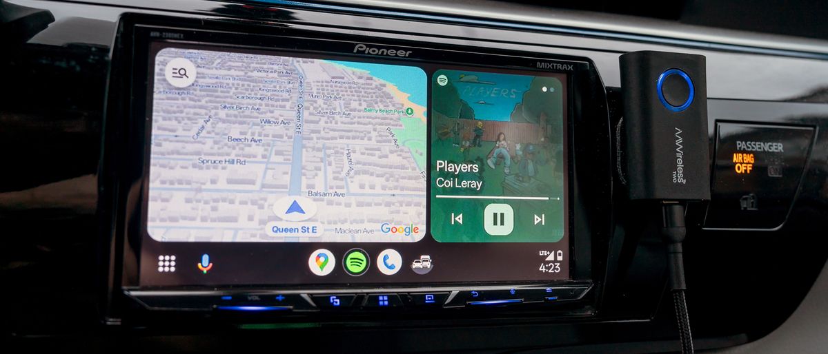 AAWireless Two Android Auto wireless adapter next to vehicle infotainment screen.