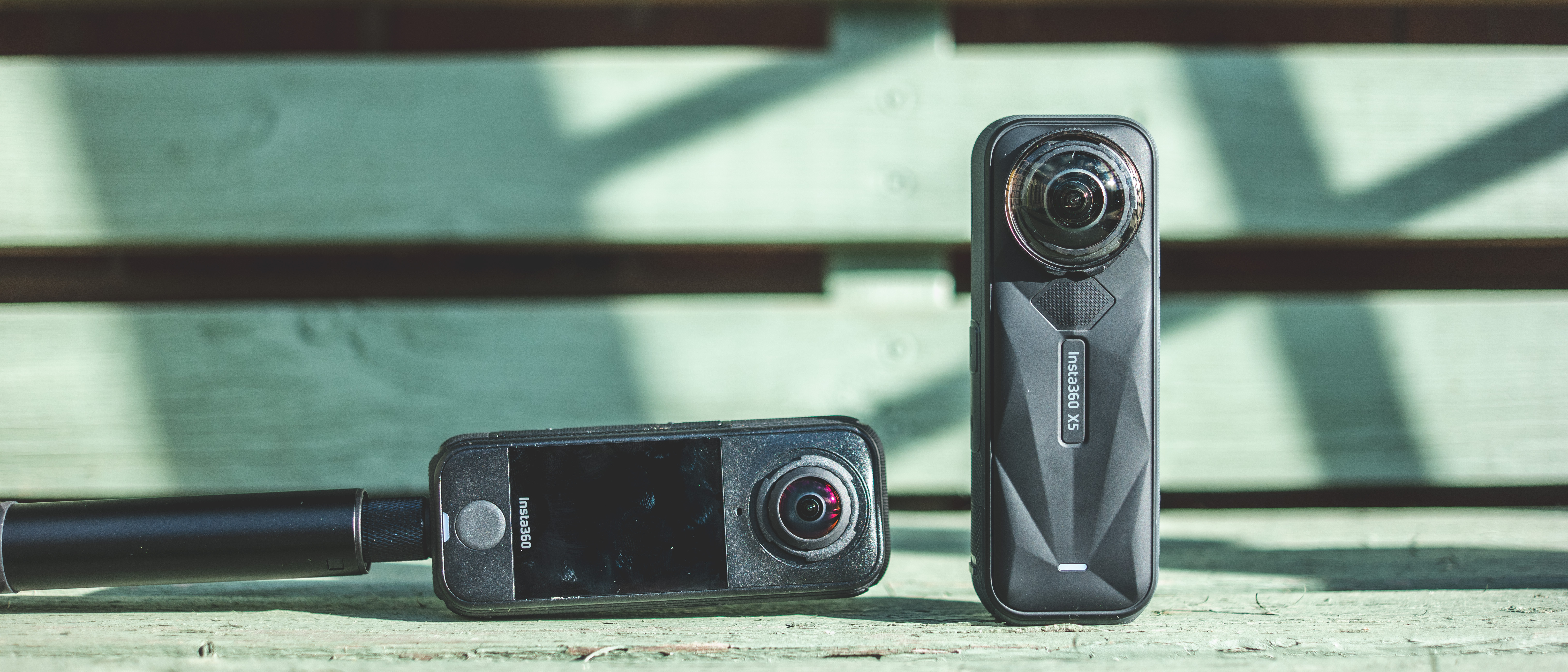 The Insta360 X5 and X4 Air action cameras in an outdoor setting under natural light